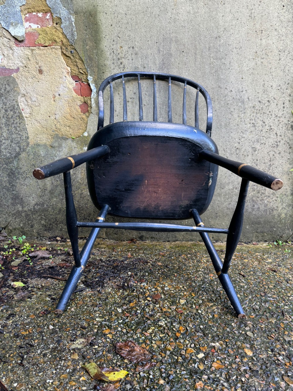 A black-painted wooden Windsor armchair featuring a hoop back with vertical spindles, curved armrests, and turned legs joined by stretchers. View XVIII