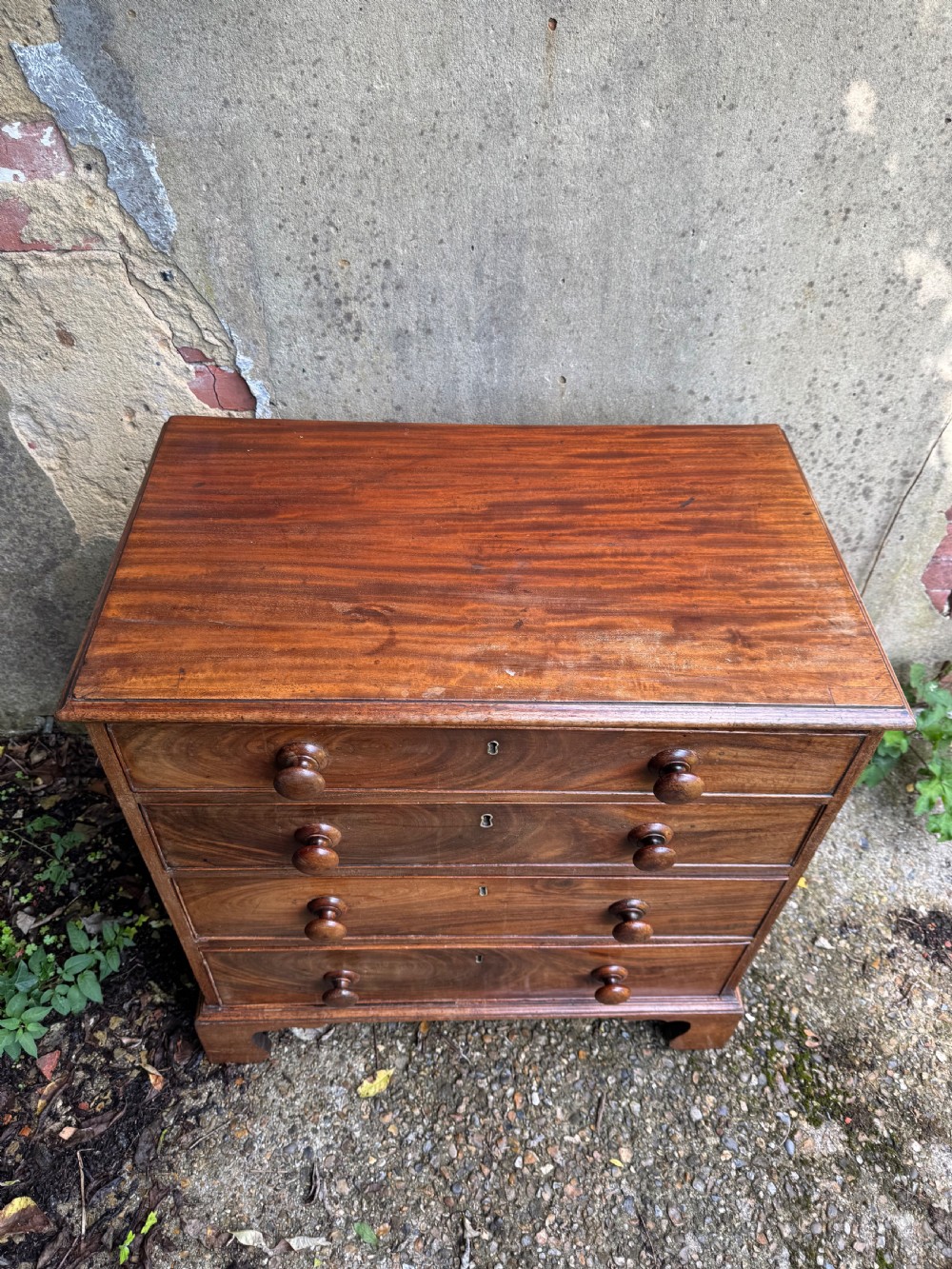 A Georgian mahogany chest featuring four graduated drawers with turned wooden knobs, keyhole escutcheons, and classic bracket feet. View VII