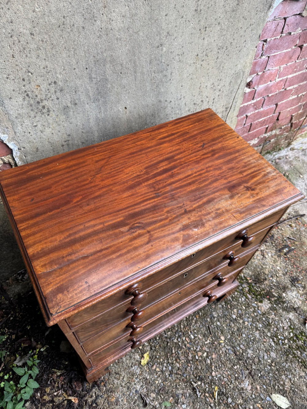 A Georgian mahogany chest featuring four graduated drawers with turned wooden knobs, keyhole escutcheons, and classic bracket feet. View X