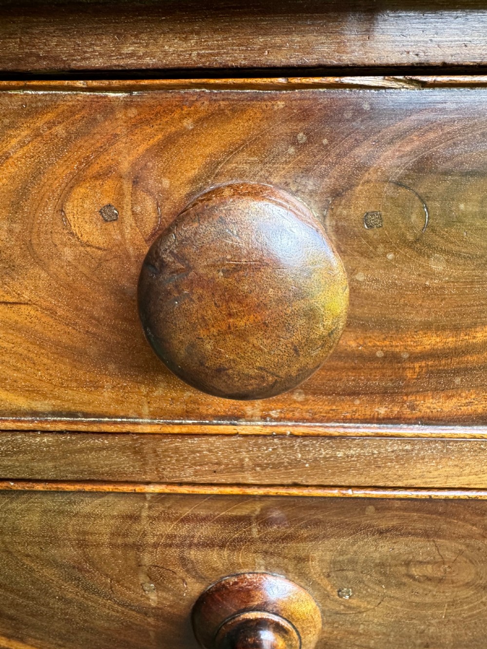 A Georgian mahogany chest featuring four graduated drawers with turned wooden knobs, keyhole escutcheons, and classic bracket feet. View XIV