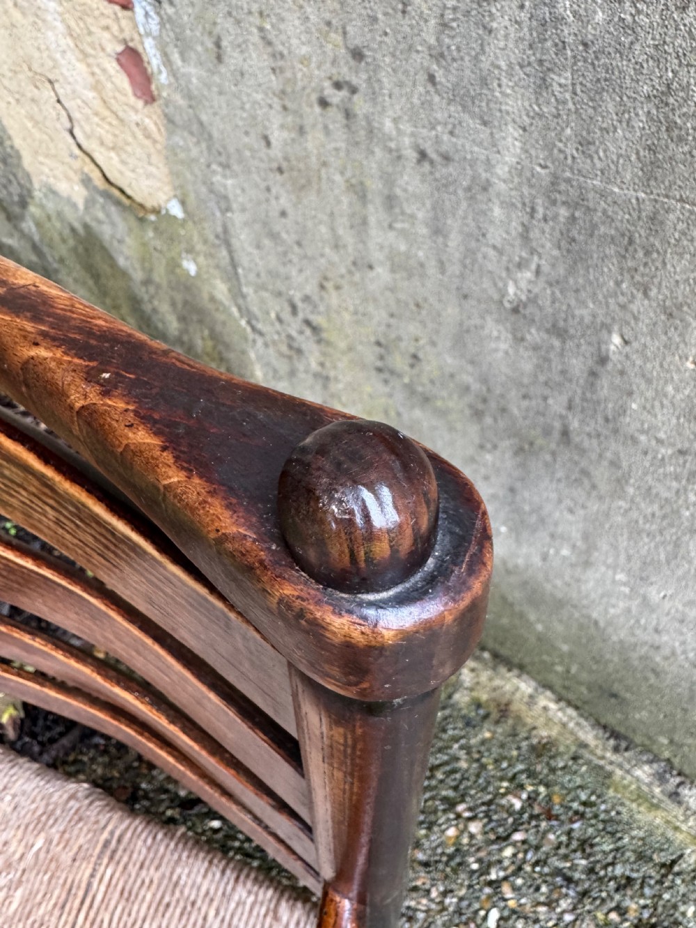 An antique dark wood Sussex armchair featuring a slatted backrest, turned front legs and stretchers, shaped armrests, and a hand-woven rush seat. View XXVIII