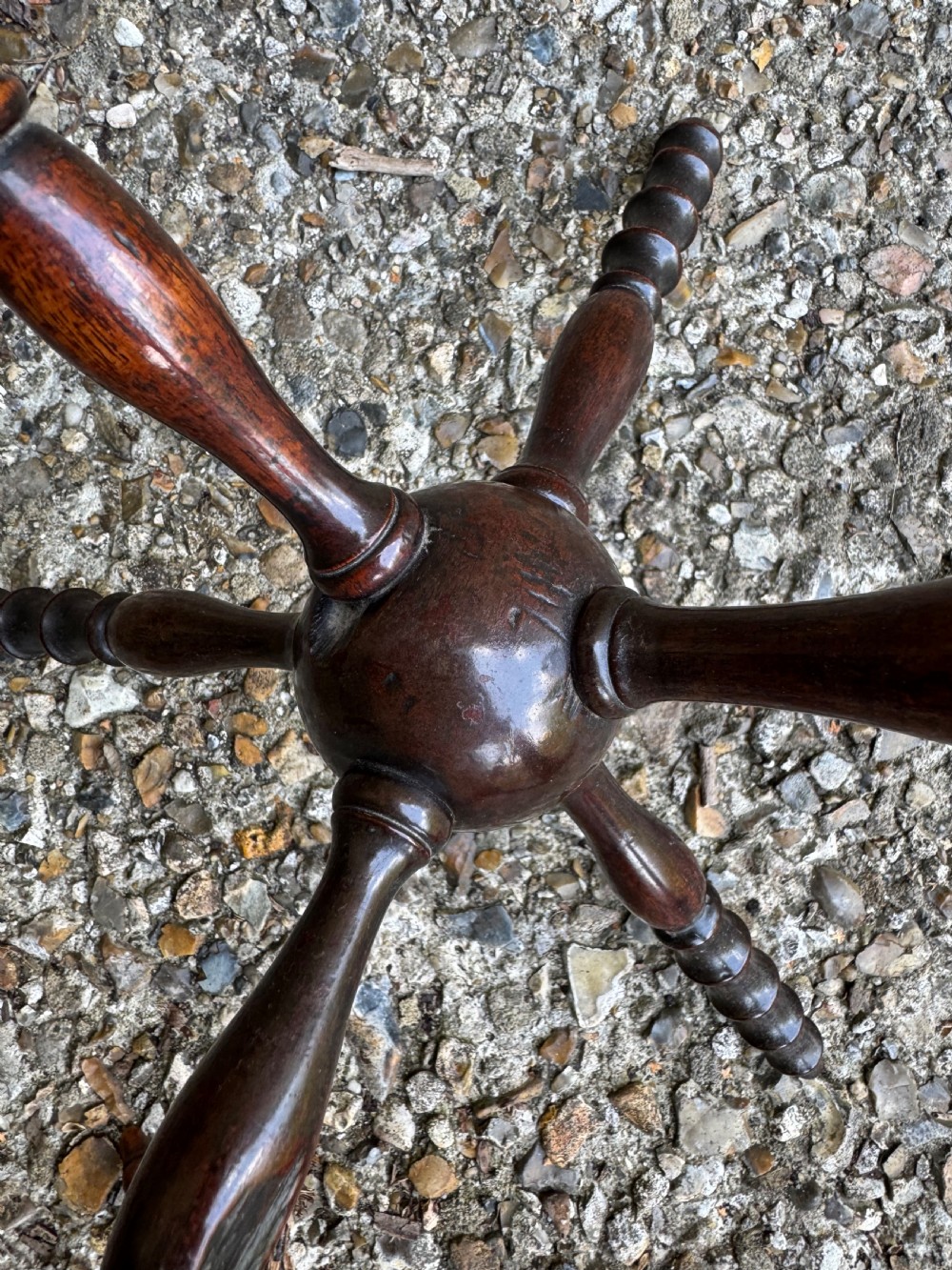 A dark turned wooden cat stand featuring six turned spindle legs radiating from a central sphere. View II