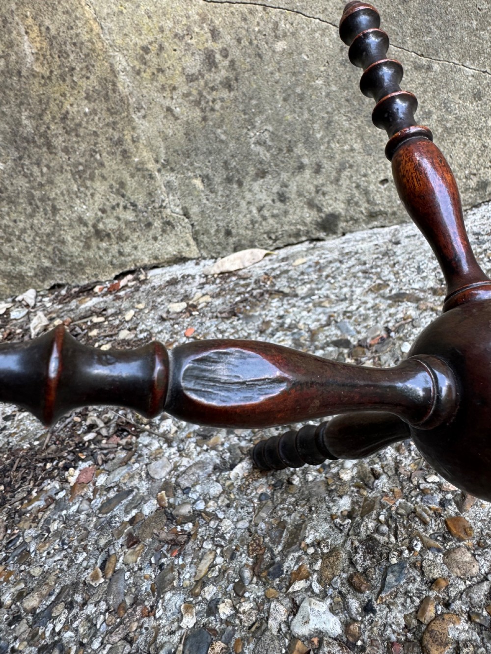 A dark turned wooden cat stand featuring six turned spindle legs radiating from a central sphere. View III