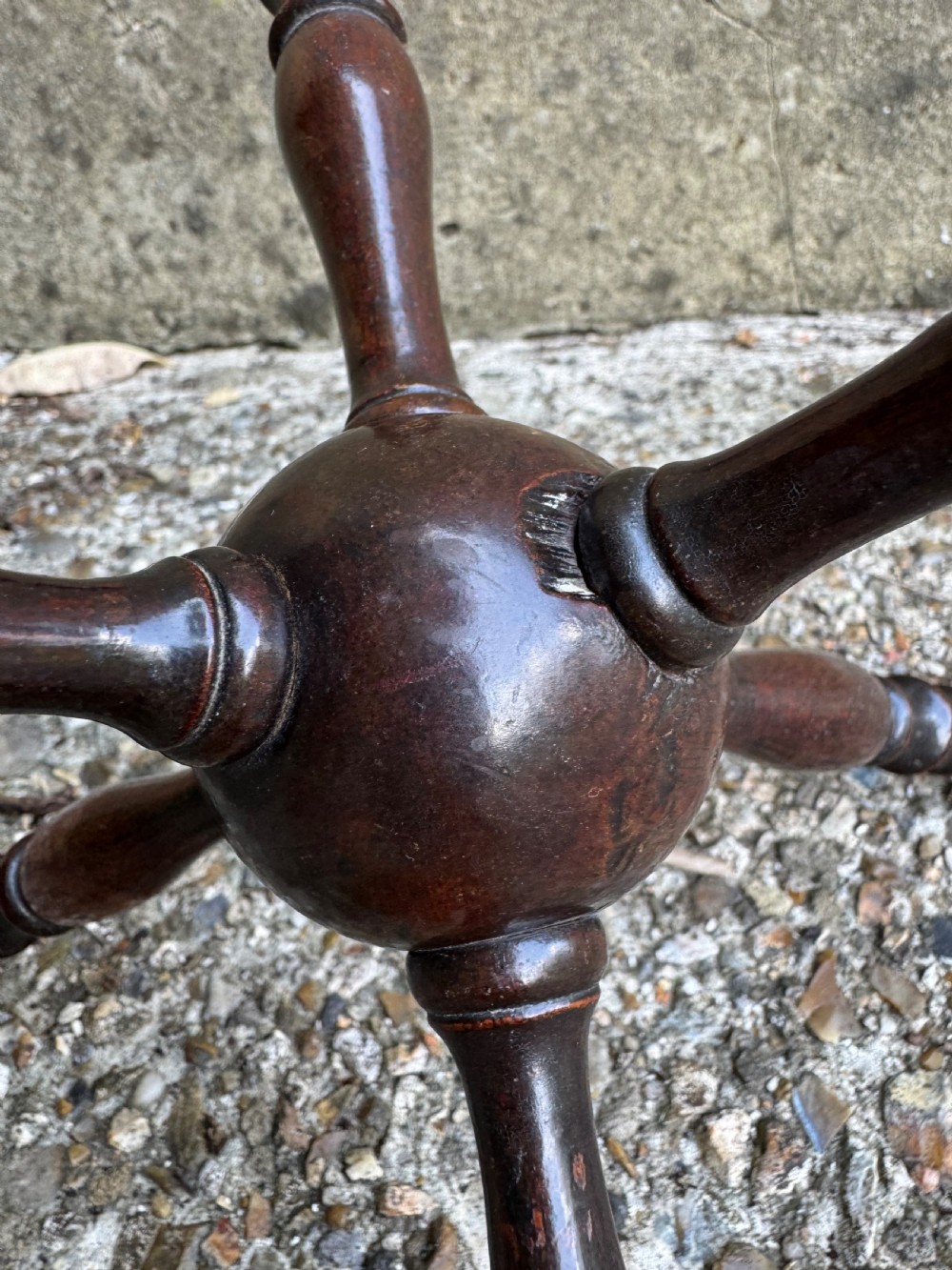 A dark turned wooden cat stand featuring six turned spindle legs radiating from a central sphere. View VII