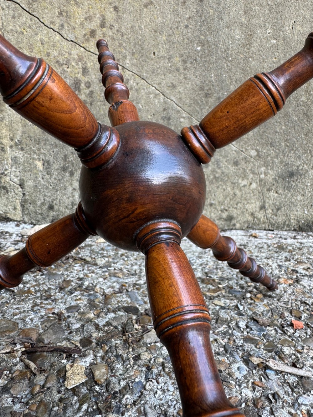 A dark turned wood six-spoked cat stand featuring bobbin-style spindle legs radiating from a central spherical hub. View II