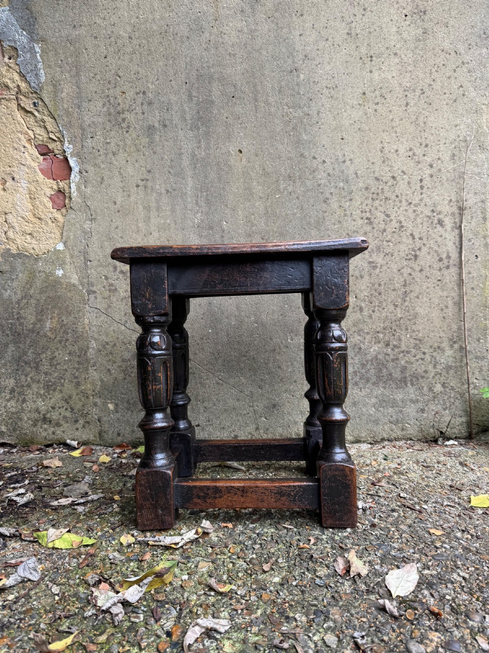 A dark oak joint stool featuring turned baluster legs, lower perimeter stretchers, and a flat rectangular top. View II