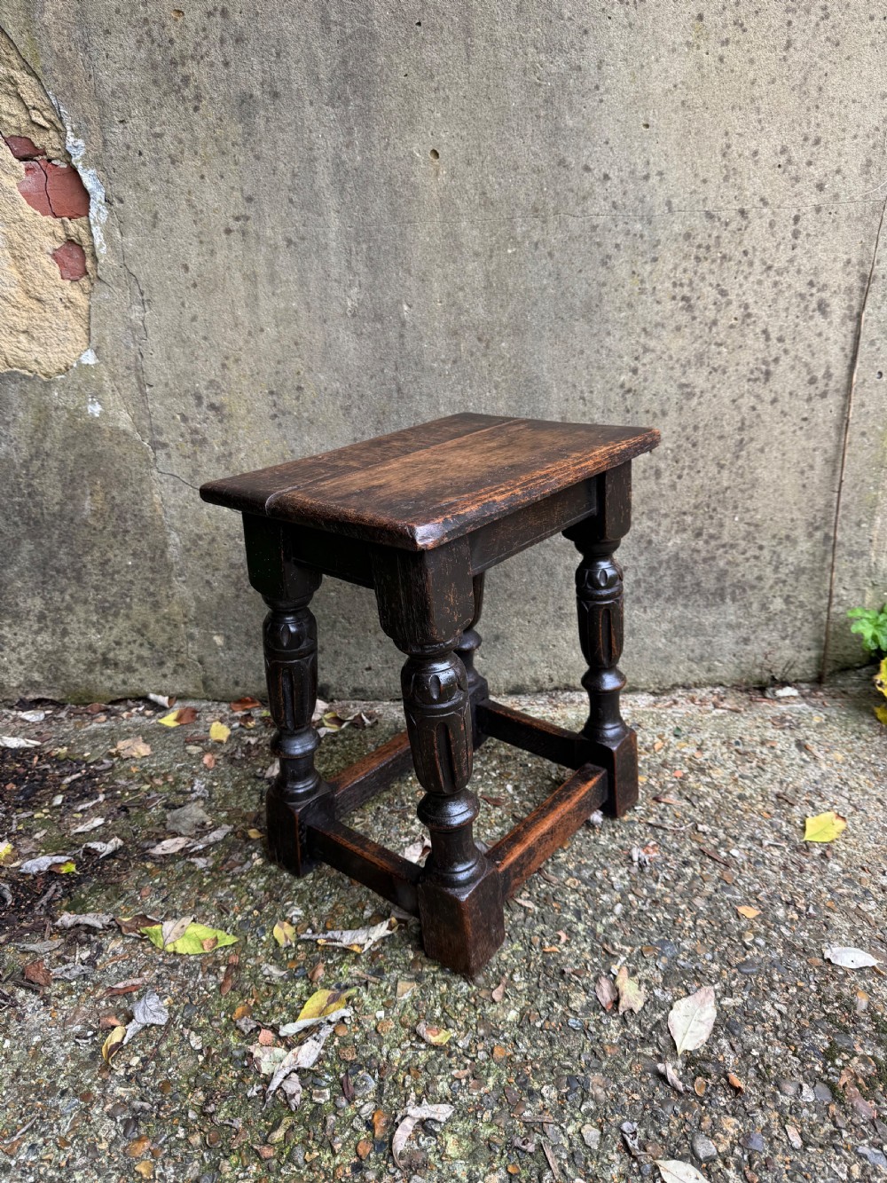 A dark oak joint stool featuring turned baluster legs, lower perimeter stretchers, and a flat rectangular top. View VI