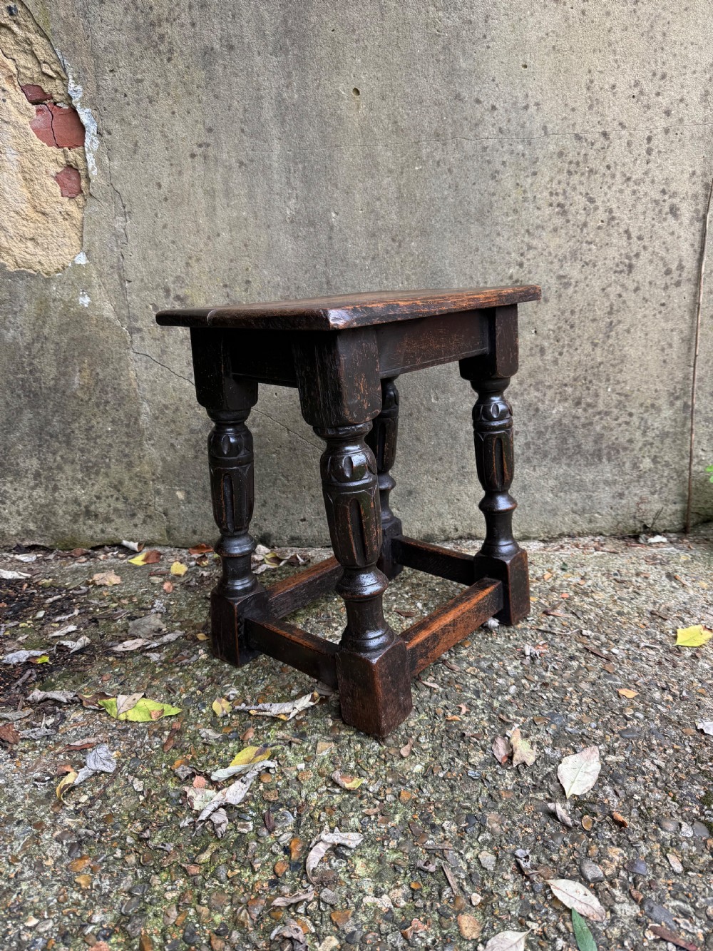 A dark oak joint stool featuring turned baluster legs, lower perimeter stretchers, and a flat rectangular top. View VII