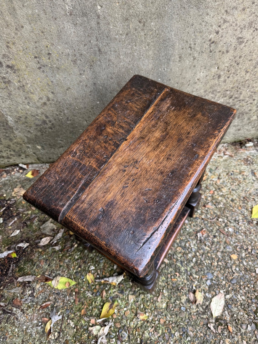 A dark oak joint stool featuring turned baluster legs, lower perimeter stretchers, and a flat rectangular top. View IX