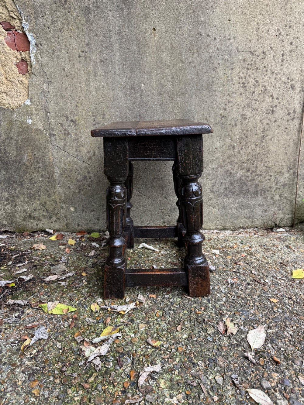 A dark oak joint stool featuring turned baluster legs, lower perimeter stretchers, and a flat rectangular top. View XI