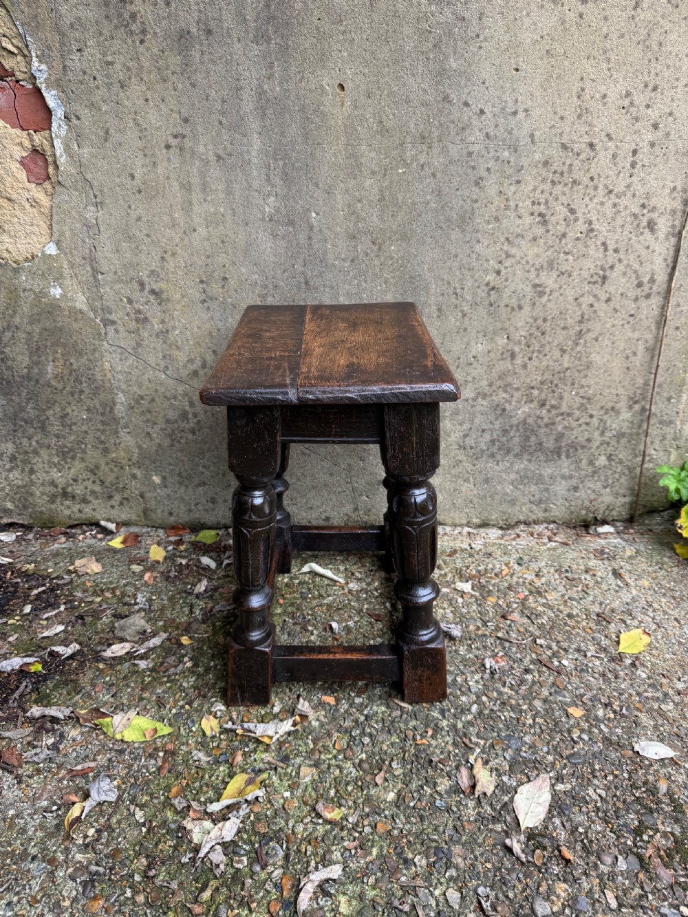 A dark oak joint stool featuring turned baluster legs, lower perimeter stretchers, and a flat rectangular top. View XII