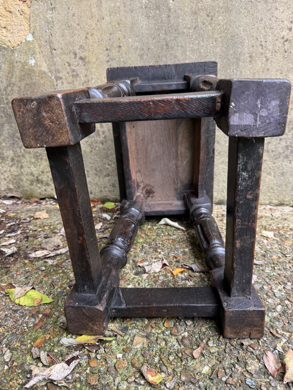 A dark oak joint stool featuring turned baluster legs, lower perimeter stretchers, and a flat rectangular top. View XVII