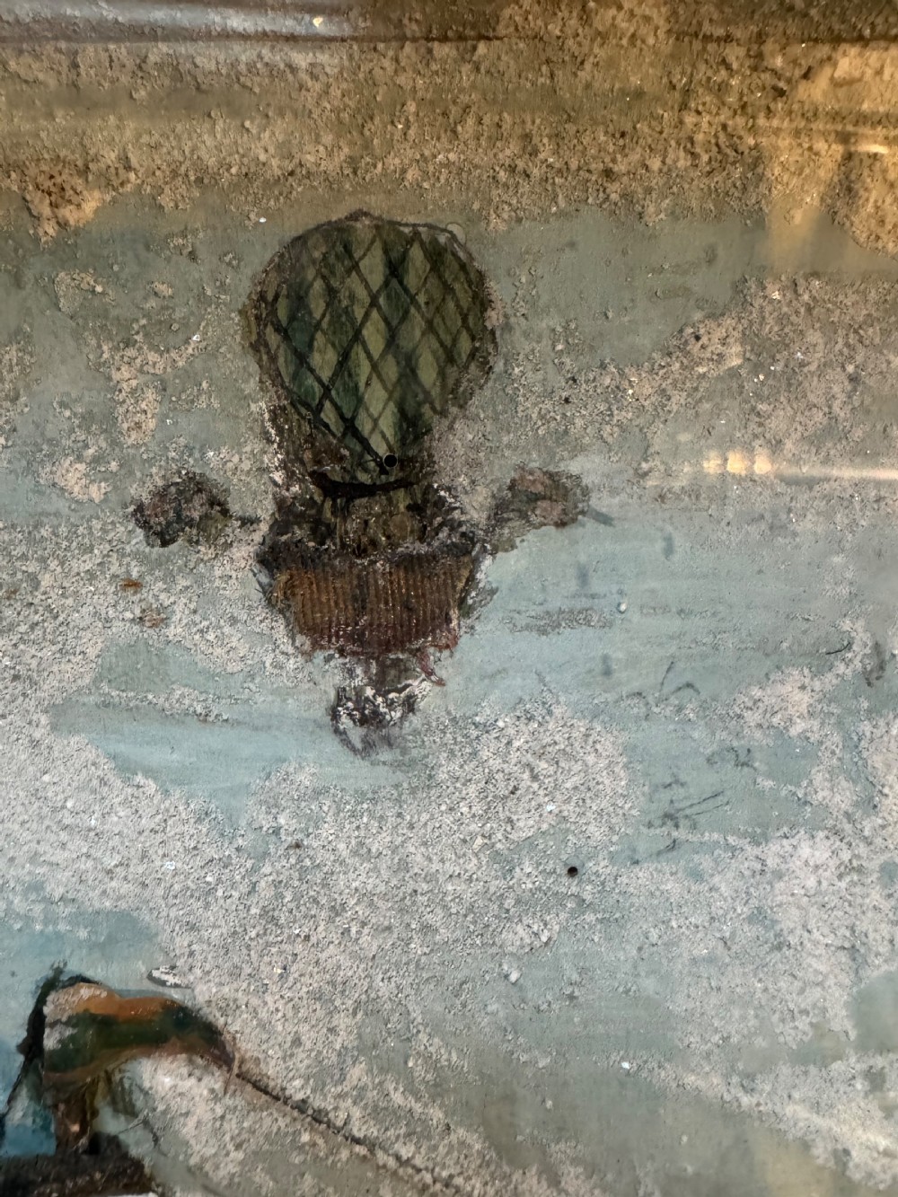 A framed shadow box diorama depicting a three-masted sailing ship on a painted plaster sea beside a rocky cliff and lighthouse. View VIII