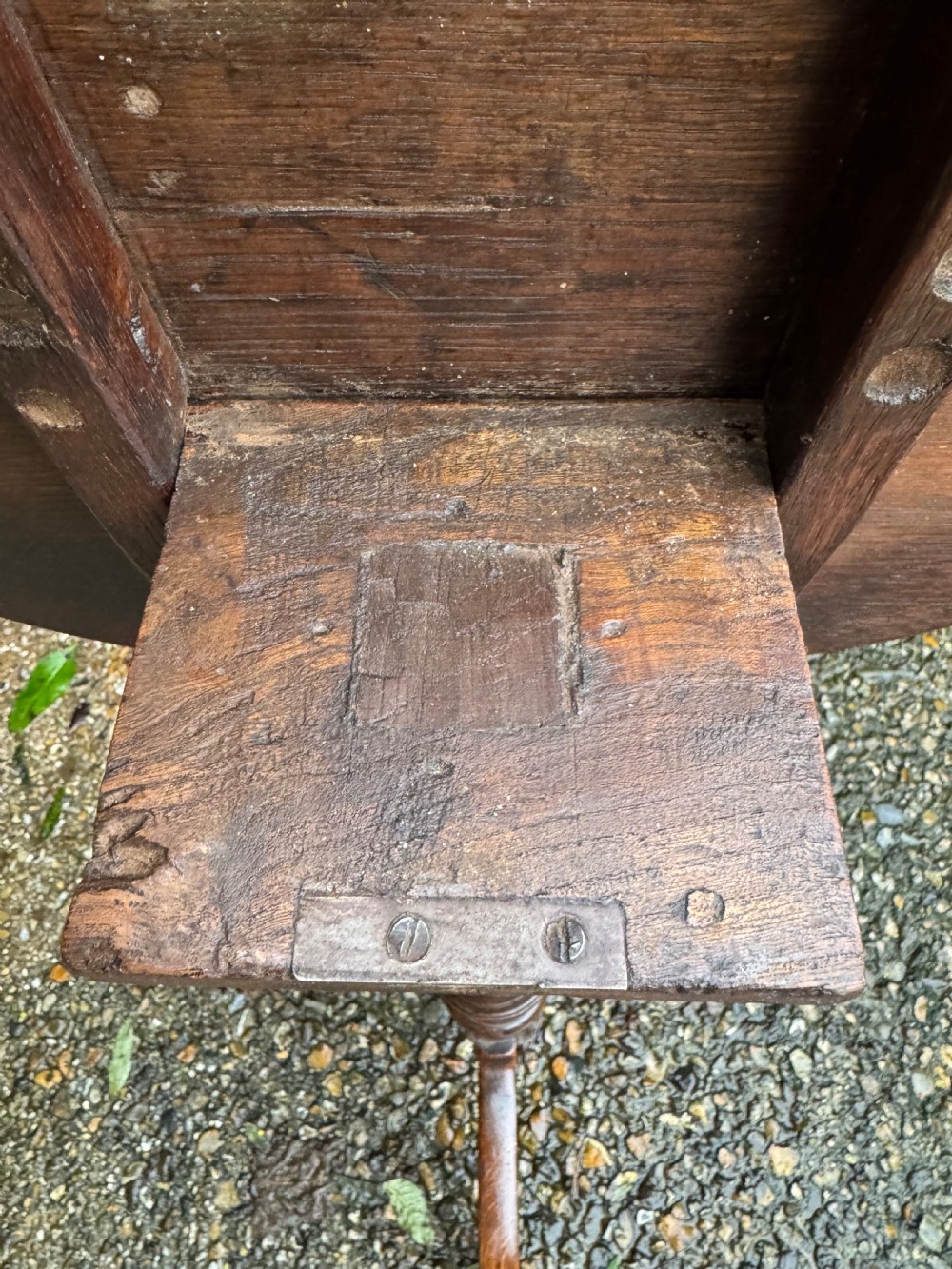 An antique dark oak circular tripod table with a turned central stem, three pad-foot legs, and a tilt-top mechanism. View XII