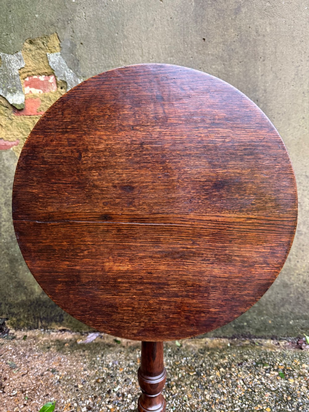 An antique dark oak circular tripod table with a turned central stem, three pad-foot legs, and a tilt-top mechanism. View XIII