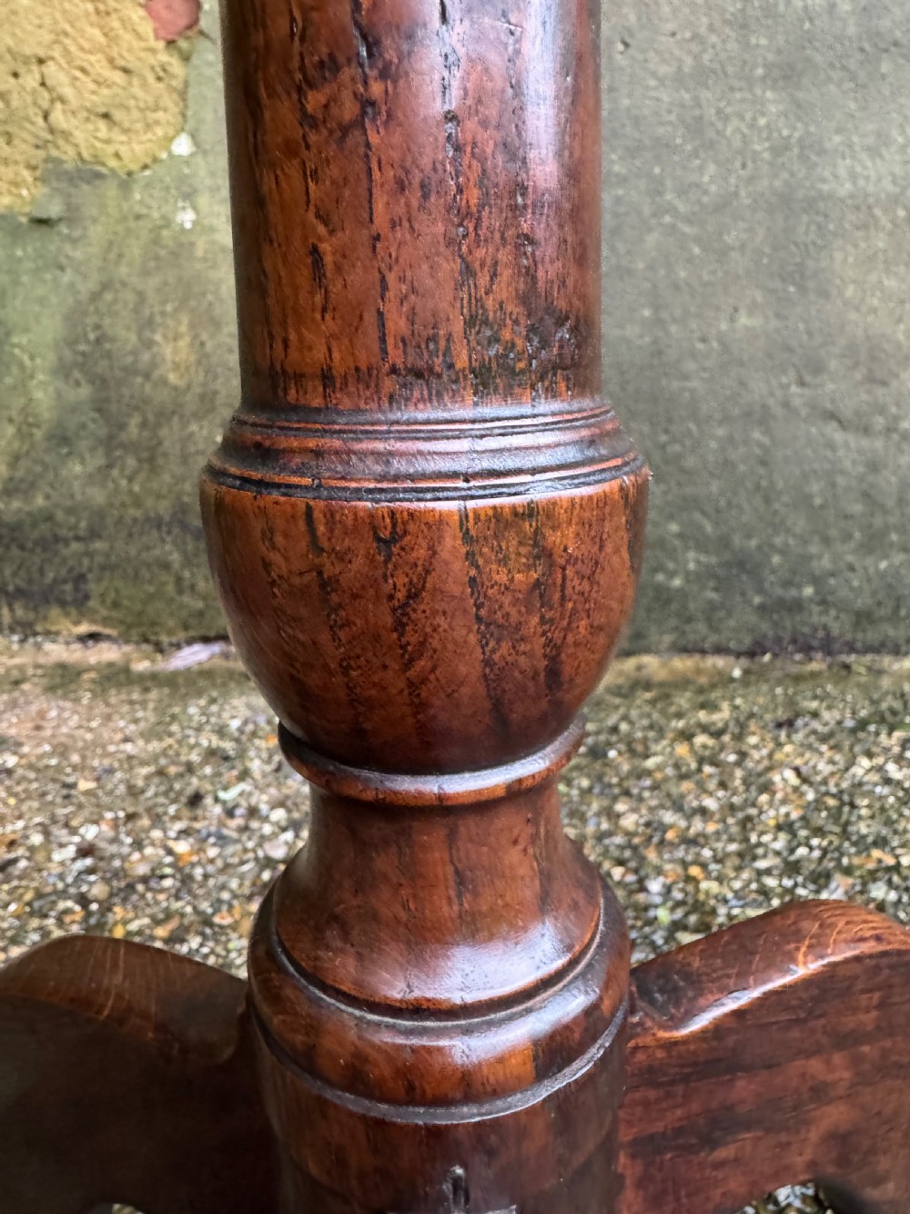 An antique dark oak circular tripod table with a turned central stem, three pad-foot legs, and a tilt-top mechanism. View XV