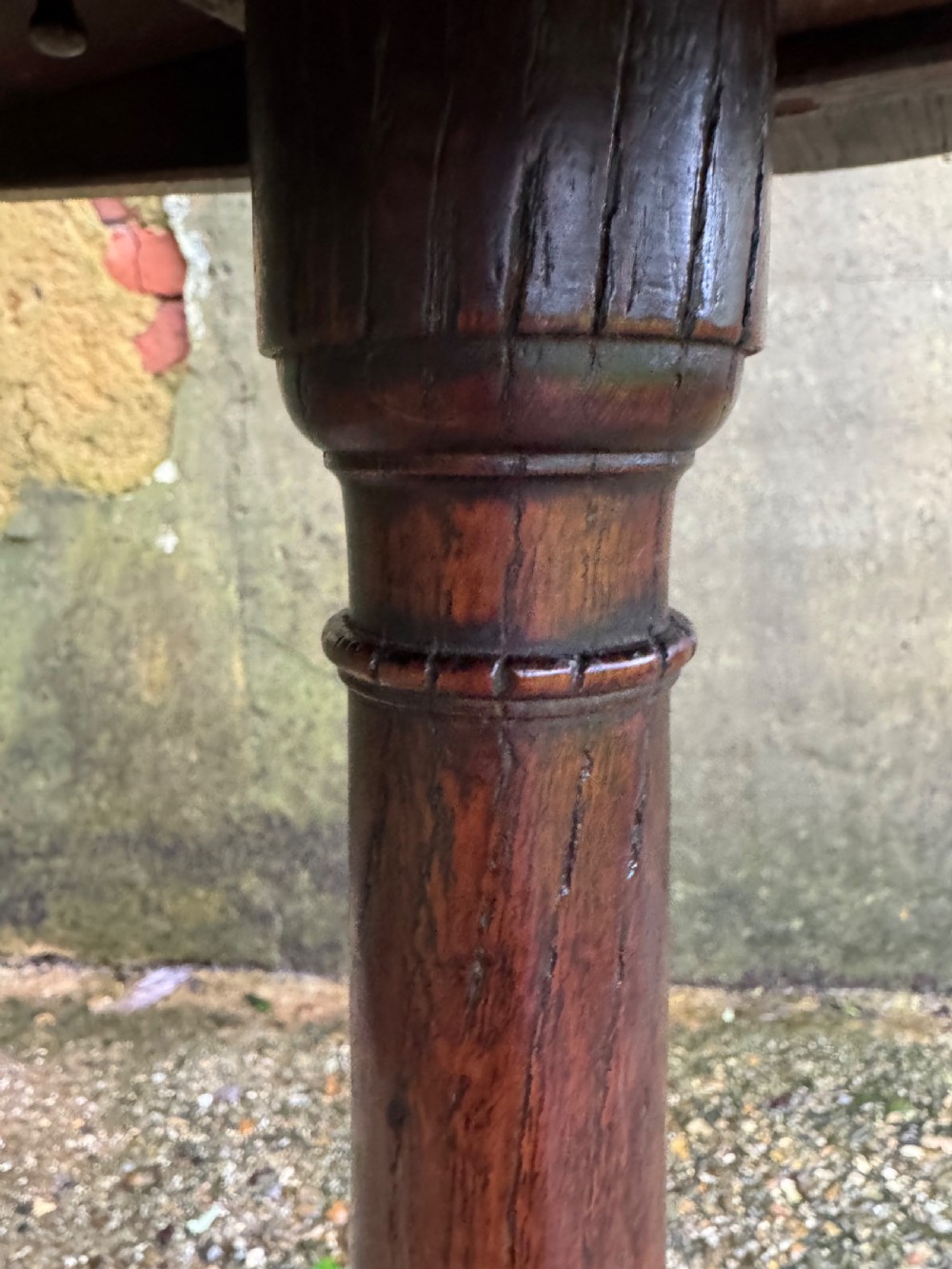 An antique dark oak circular tripod table with a turned central stem, three pad-foot legs, and a tilt-top mechanism. View XVI
