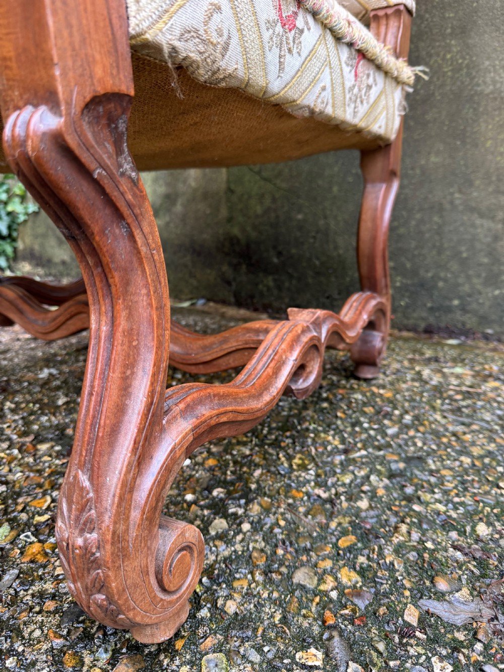 A French style carved walnut armchair featuring a tall backrest, scrolled armrests, patterned cream and pink upholstery, and intricately carved legs. View XI