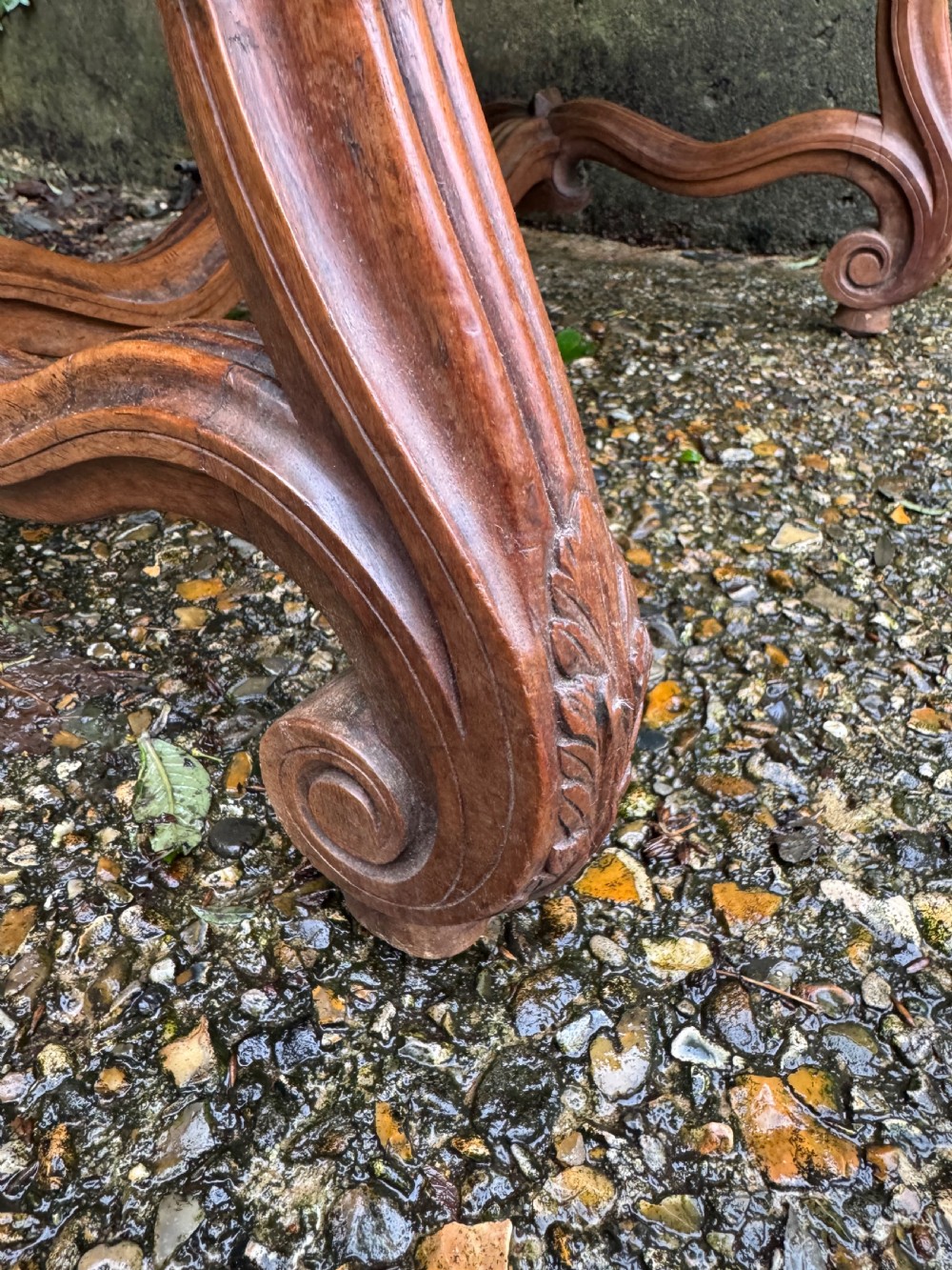 A French style carved walnut armchair featuring a tall backrest, scrolled armrests, patterned cream and pink upholstery, and intricately carved legs. View XV