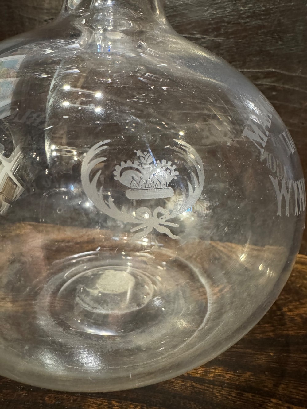 A clear bulbous glass wine flagon featuring etched lettering reading Max Greger and Co London Wine Flagon with a matching glass stopper. View V