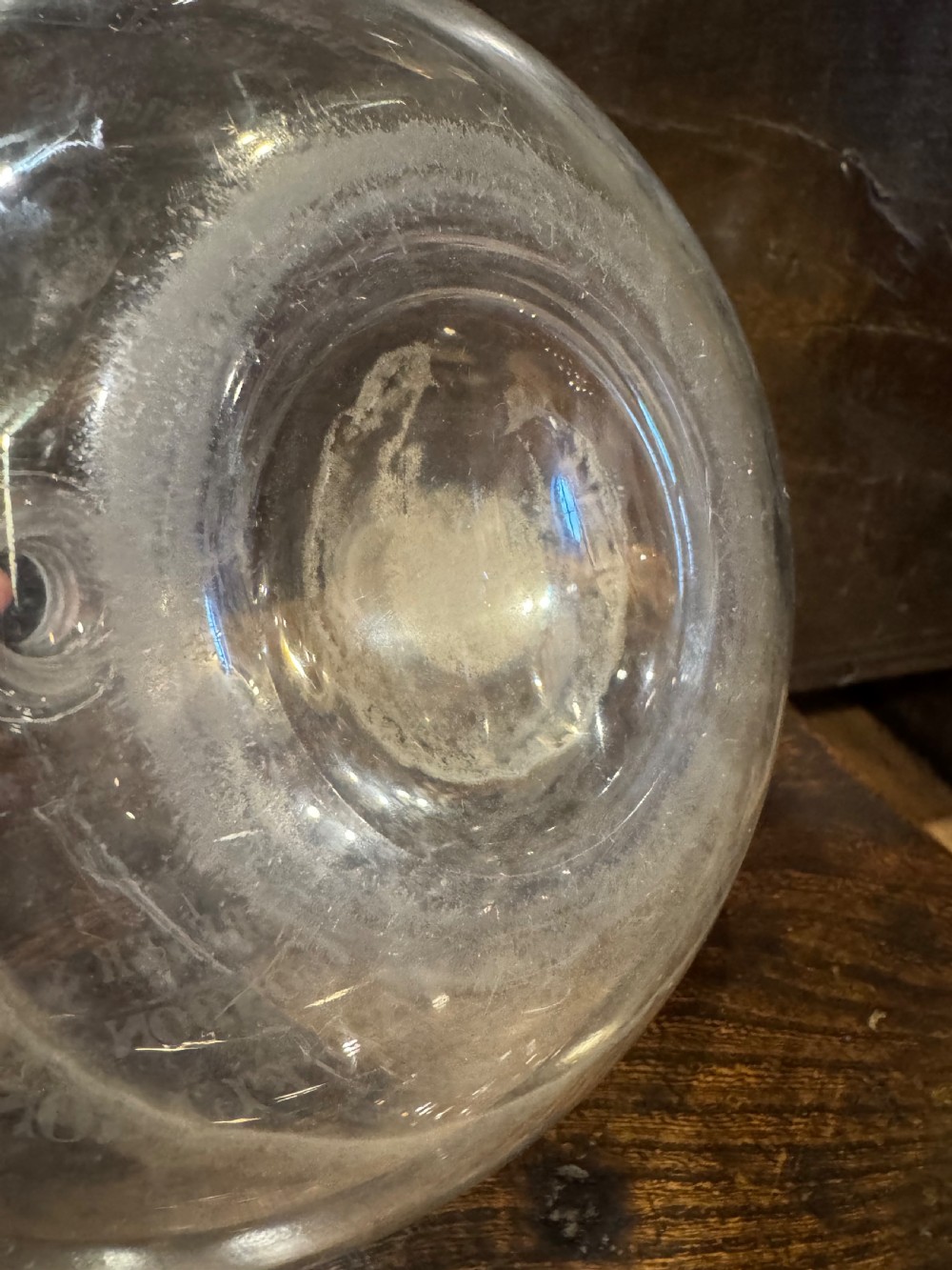 A clear bulbous glass wine flagon featuring etched lettering reading Max Greger and Co London Wine Flagon with a matching glass stopper. View VI