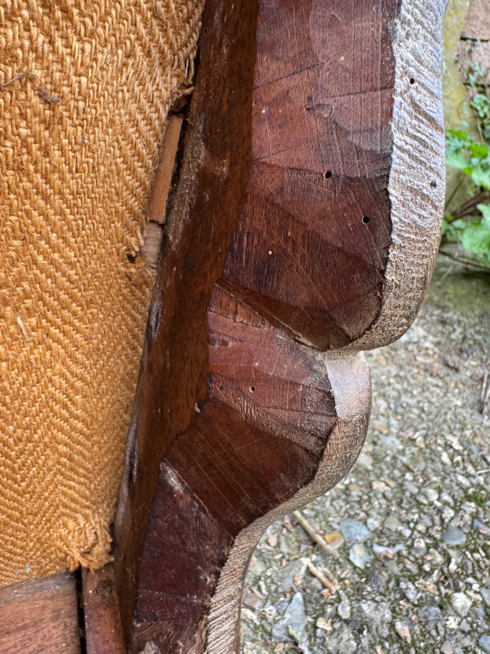 An antique French wooden armchair featuring red fabric upholstery, scrolled arms, brass stud trimming, and a rectangular stretcher base. View XIII