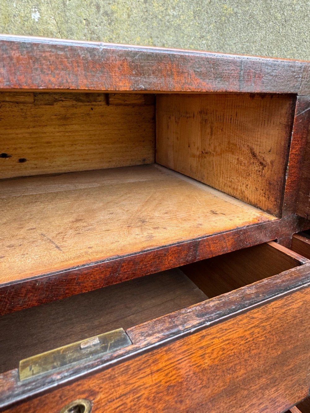 A dark Georgian mahogany flight of nine drawers with brass keyhole escutcheons resting on short bracket feet. View XI