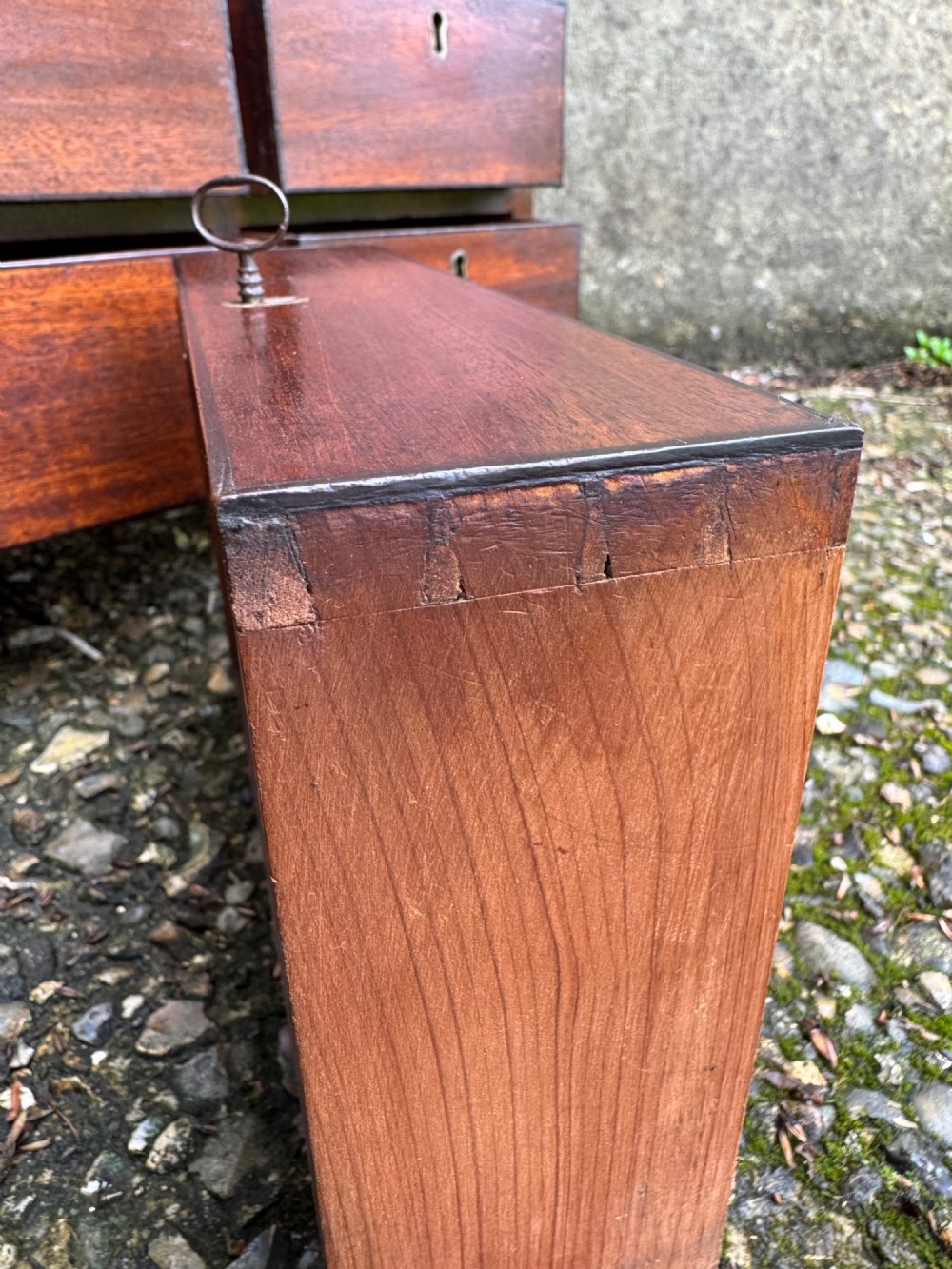 A dark Georgian mahogany flight of nine drawers with brass keyhole escutcheons resting on short bracket feet. View XII