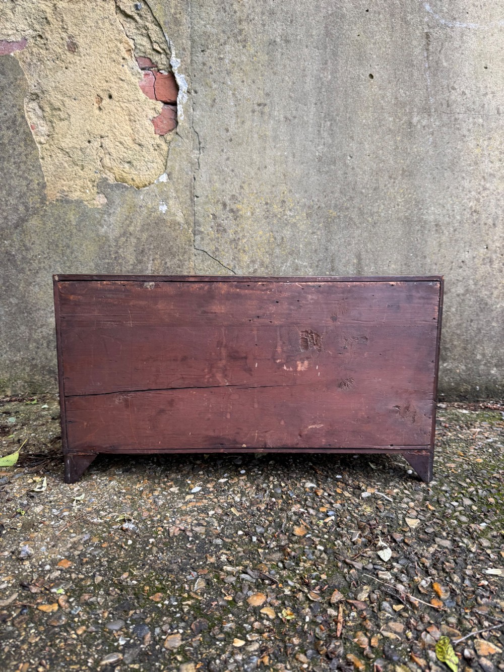 A dark Georgian mahogany flight of nine drawers with brass keyhole escutcheons resting on short bracket feet. View XV