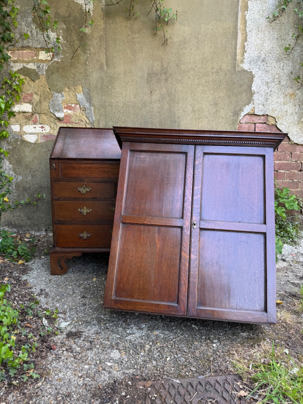 An antique warm brown oak bureau bookcase featuring twin fielded panel upper doors, a slant-front desk, and multiple drawers with brass hardware. View III