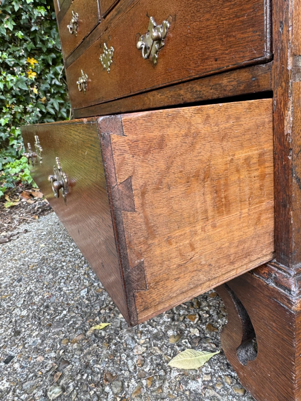 An antique warm brown oak bureau bookcase featuring twin fielded panel upper doors, a slant-front desk, and multiple drawers with brass hardware. View IX