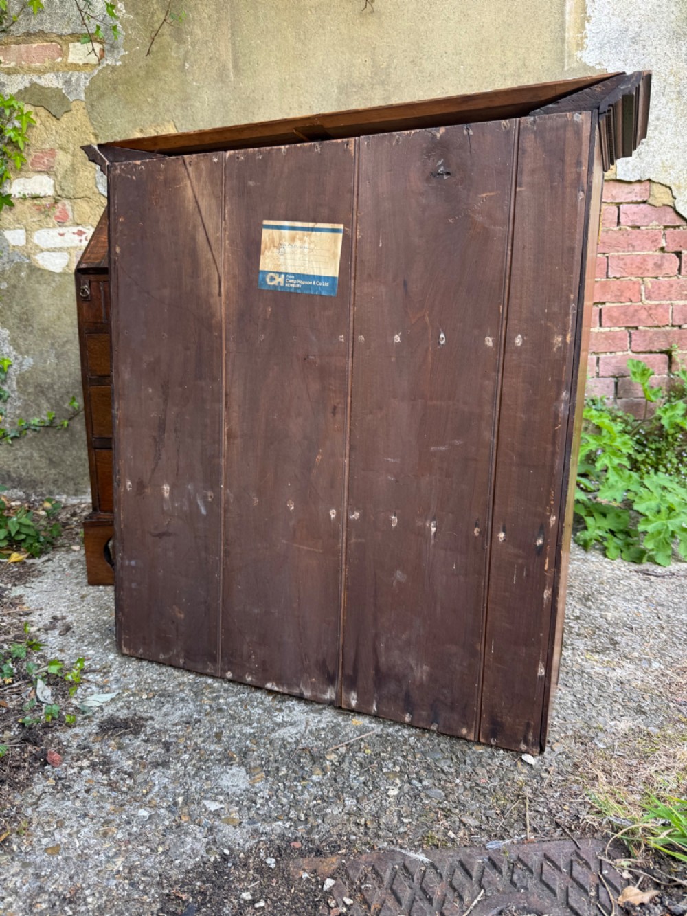 An antique warm brown oak bureau bookcase featuring twin fielded panel upper doors, a slant-front desk, and multiple drawers with brass hardware. View XI