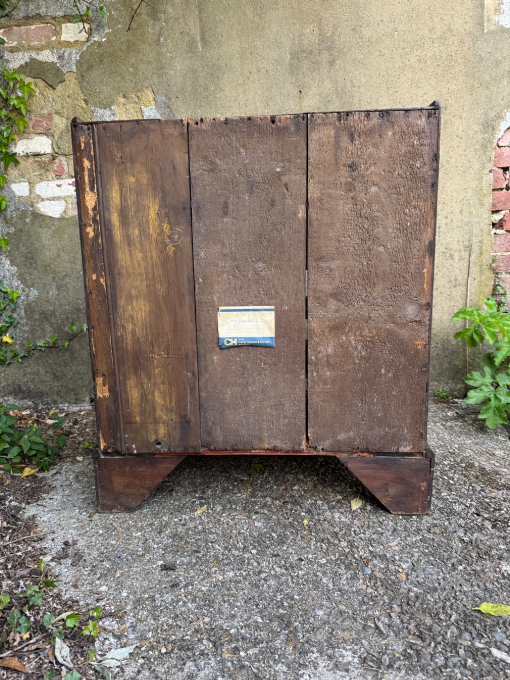 An antique warm brown oak bureau bookcase featuring twin fielded panel upper doors, a slant-front desk, and multiple drawers with brass hardware. View XII