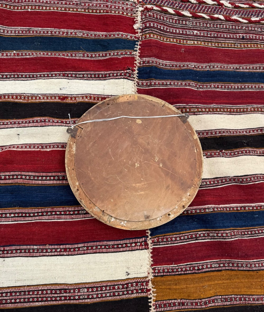 A circular antique convex mirror featuring a gilded and painted frame decorated with spherical balls along the inner rim. View V