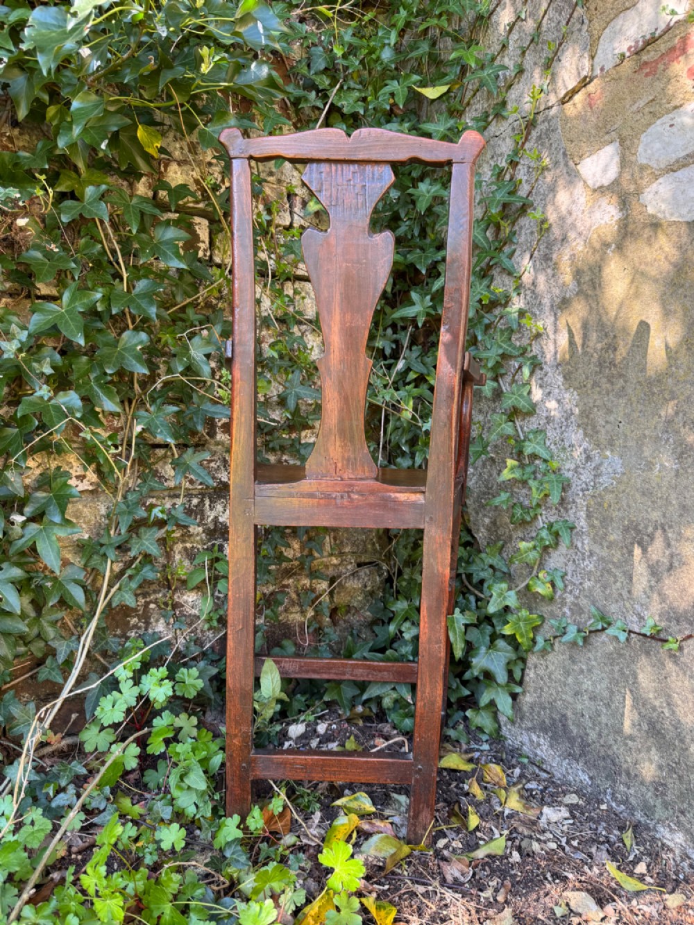 A dark brown Georgian wooden high chair with a central splat back, shaped armrests, square legs, and low wooden stretchers. View VIII