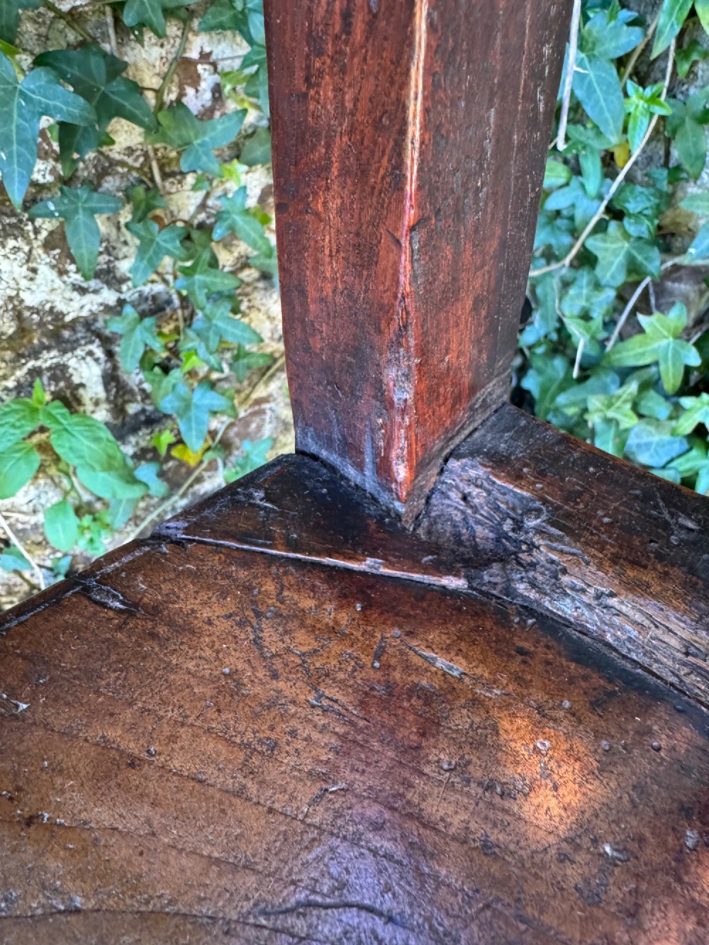 A dark brown Georgian wooden high chair with a central splat back, shaped armrests, square legs, and low wooden stretchers. View XV