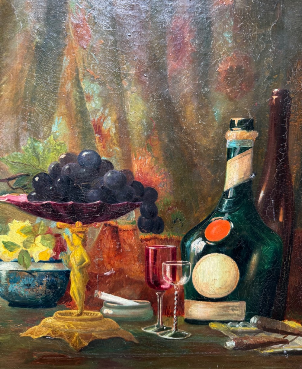 Antique framed oil painting depicting a still life composition with fruit, glassware, and bottles set in an ornate swept frame. View III