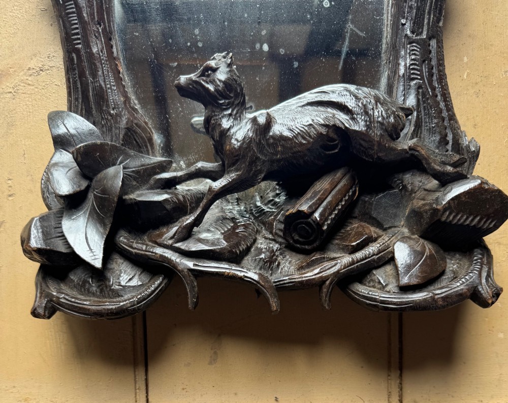 A dark hand-carved wooden wall mirror featuring a fox sculpted at the base surrounded by carved oak leaves and branches. View III