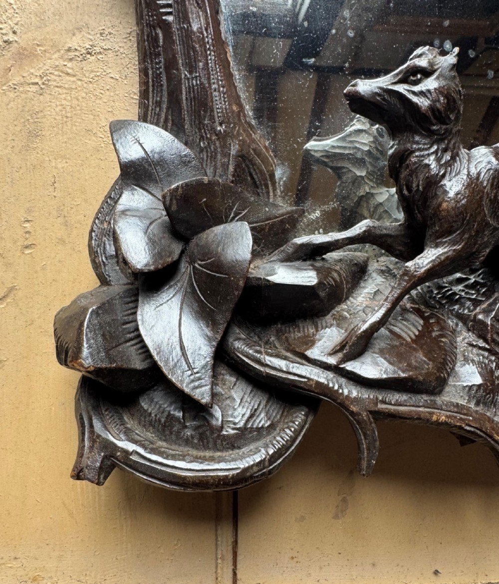A dark hand-carved wooden wall mirror featuring a fox sculpted at the base surrounded by carved oak leaves and branches. View V