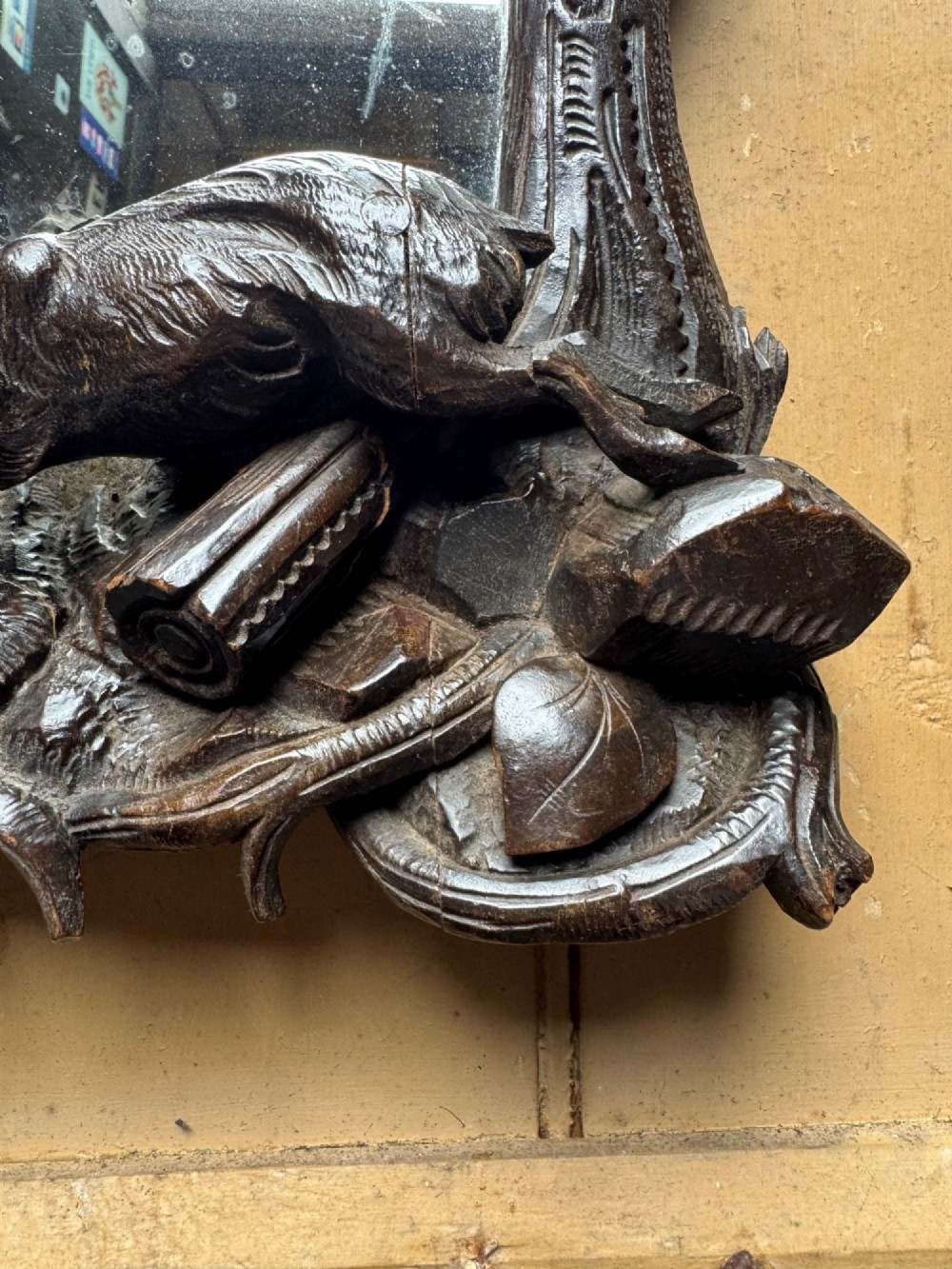 A dark hand-carved wooden wall mirror featuring a fox sculpted at the base surrounded by carved oak leaves and branches. View VI