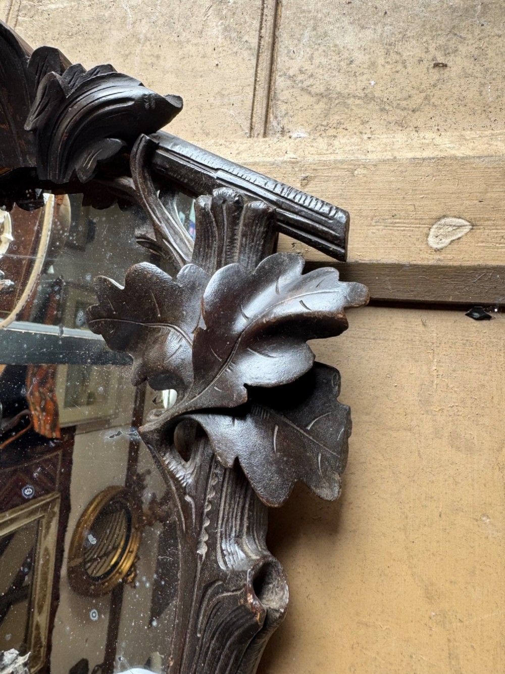 A dark hand-carved wooden wall mirror featuring a fox sculpted at the base surrounded by carved oak leaves and branches. View VIII
