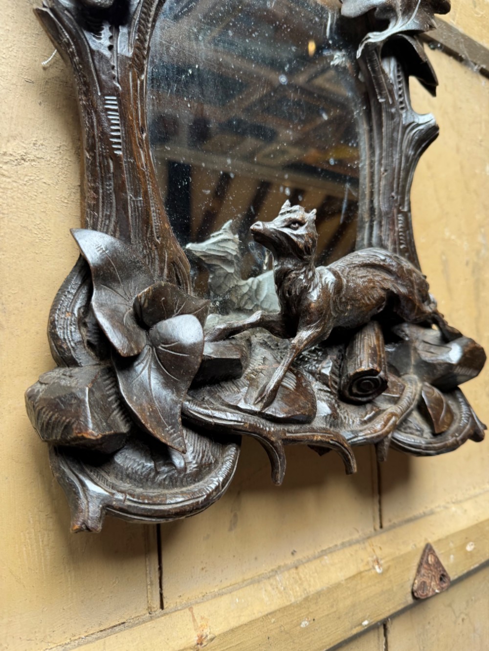 A dark hand-carved wooden wall mirror featuring a fox sculpted at the base surrounded by carved oak leaves and branches. View IX