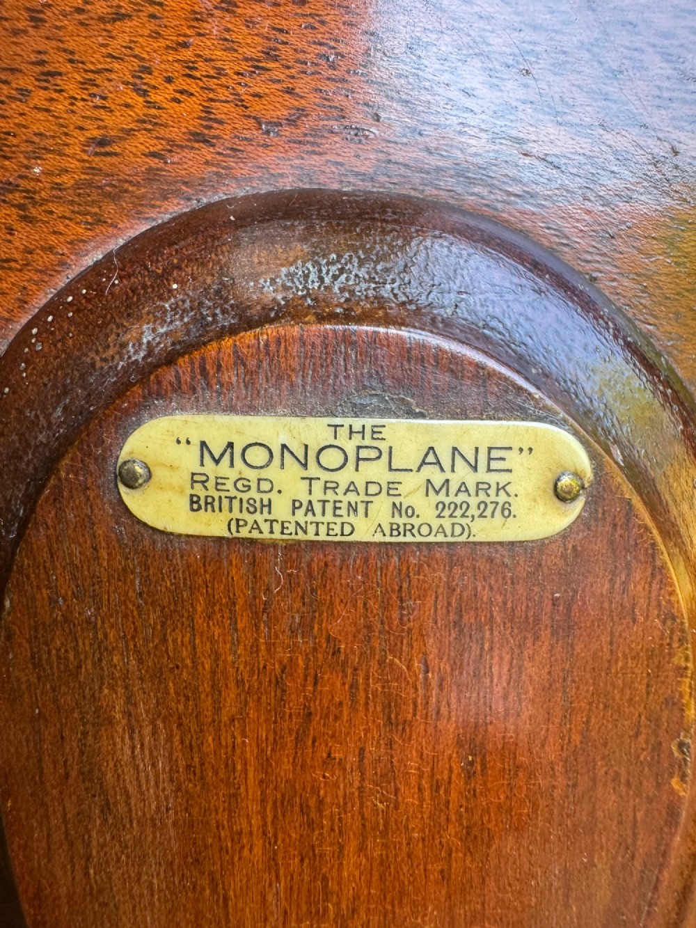 An antique mahogany monoplane folding cake stand with five circular wooden trays supported on a vertical frame with arched feet. View III