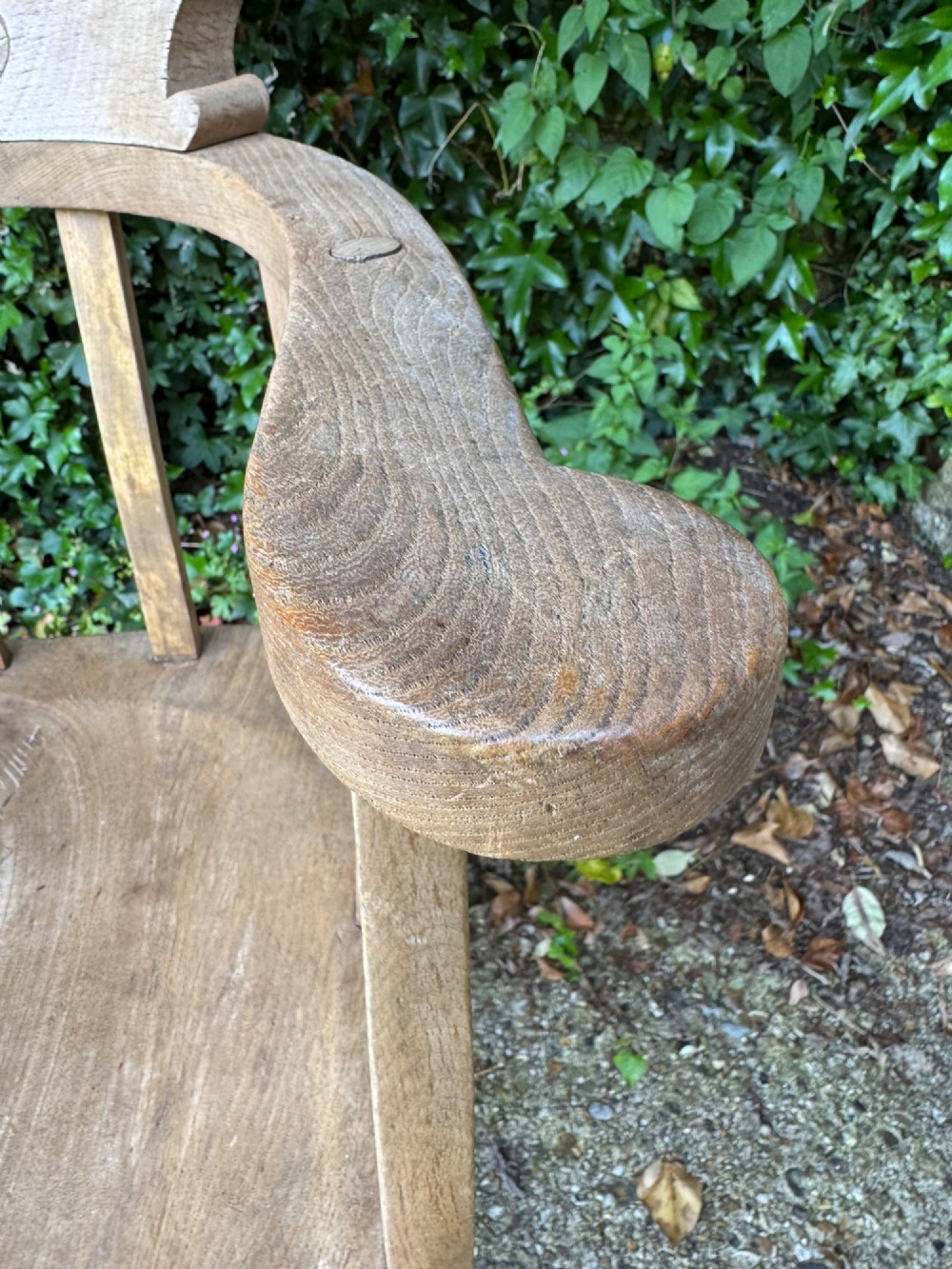 A low-backed antique oak captains armchair featuring turned legs, an H-stretcher, and vertical spindles supporting a broad curved armrest rail. View VI