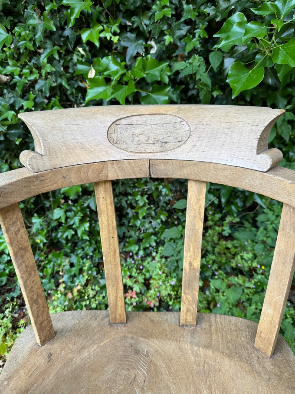 A low-backed antique oak captains armchair featuring turned legs, an H-stretcher, and vertical spindles supporting a broad curved armrest rail. View VIII