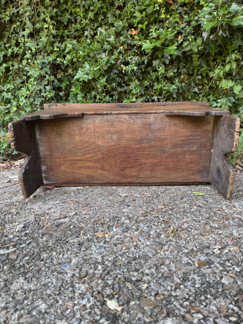 An antique dark oak plank coffer featuring notch-carved vertical edges, V-cut end feet, and a central iron lockplate. View XI