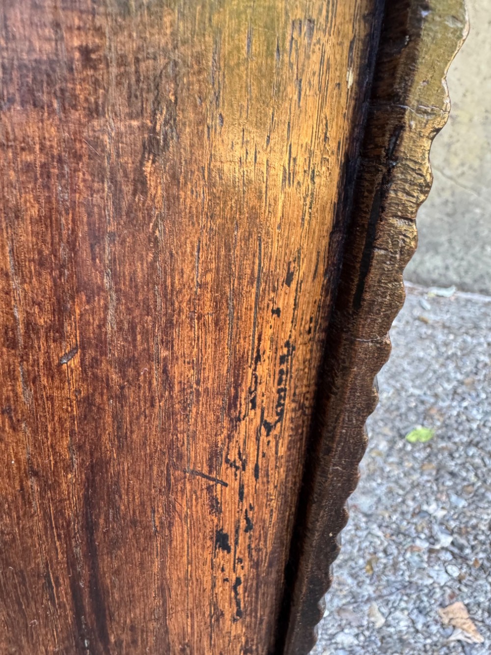 An antique dark oak plank coffer featuring notch-carved vertical edges, V-cut end feet, and a central iron lockplate. View XII