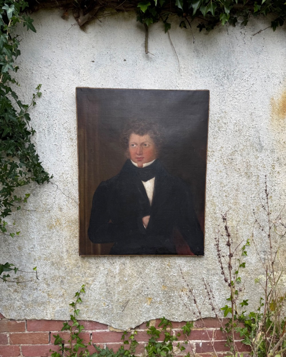 An unframed antique oil painting on canvas depicting a gentleman in a high black cravat and coat against a muted brown background. View II
