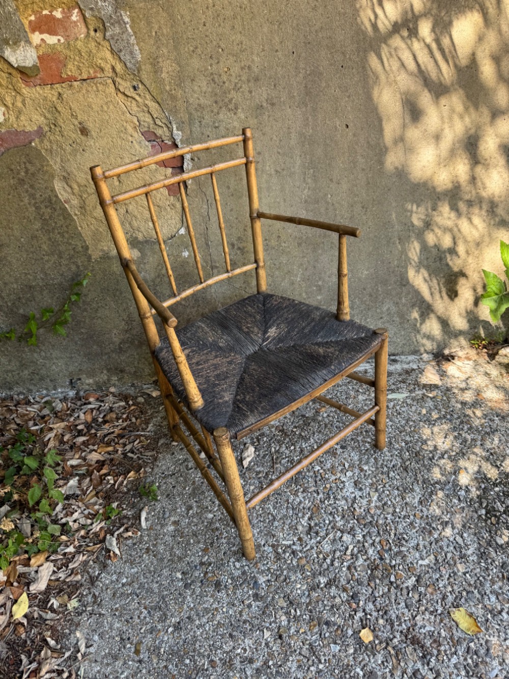 An antique turned wooden armchair with faux-bamboo detailing and a dark woven rush seat. View VI