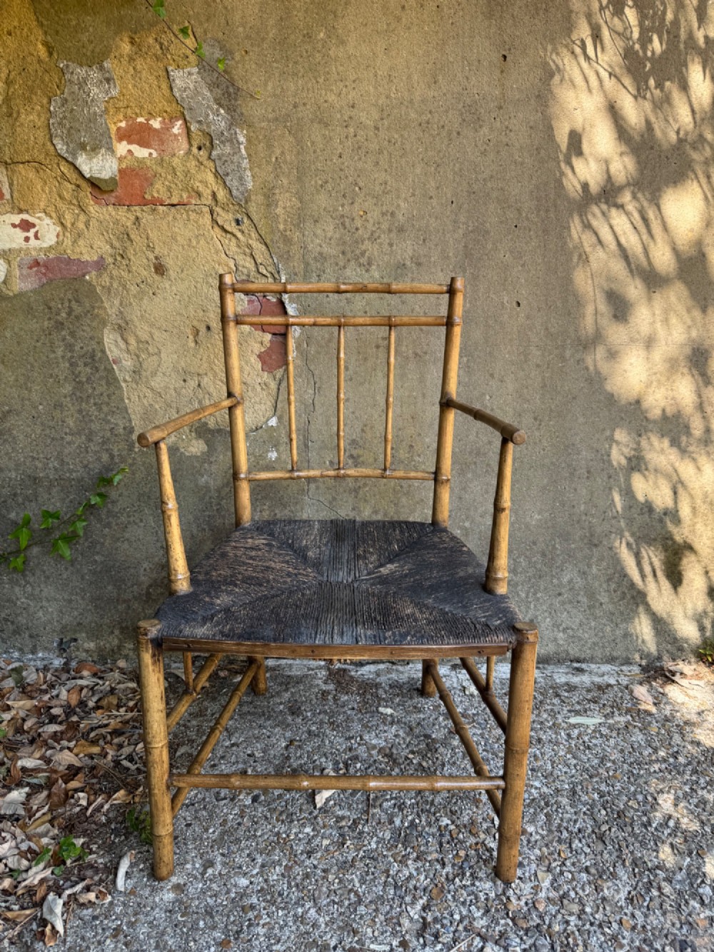 An antique turned wooden armchair with faux-bamboo detailing and a dark woven rush seat. View VII
